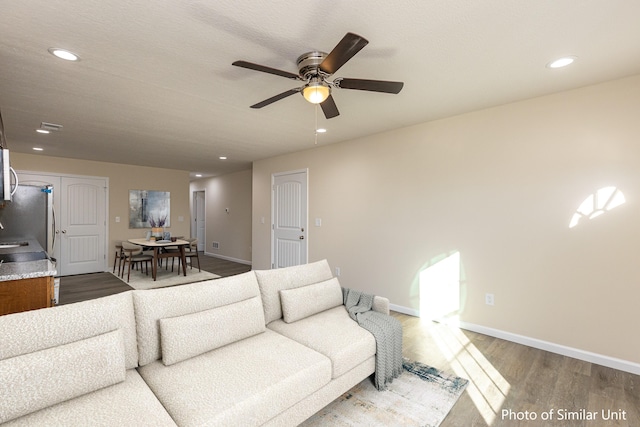 living room with ceiling fan and hardwood / wood-style flooring