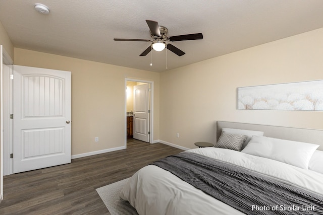 bedroom featuring ensuite bath, ceiling fan, dark wood-type flooring, and a textured ceiling