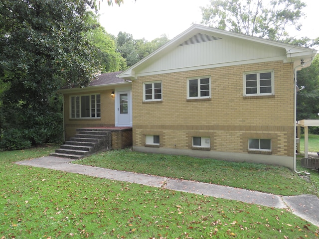 view of front of house featuring brick siding and a front yard