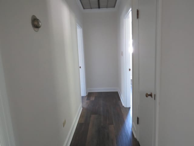 corridor featuring dark wood-style floors and baseboards