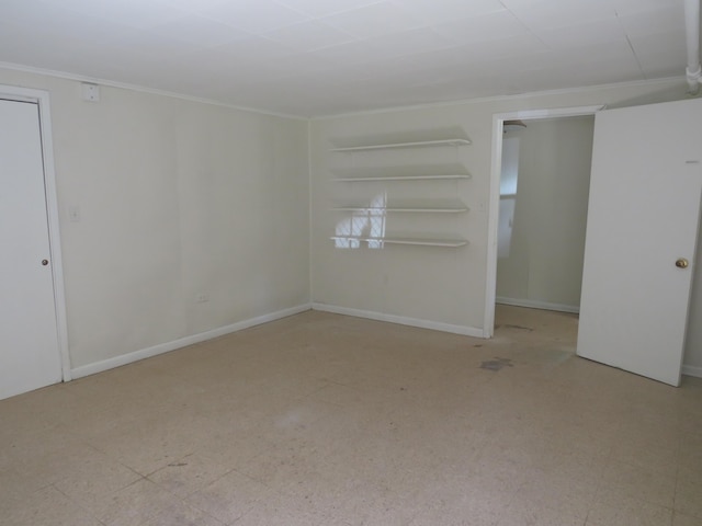 empty room featuring ornamental molding and baseboards