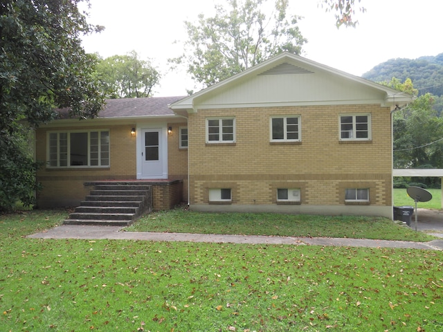 view of front of property featuring a front lawn and brick siding