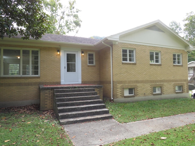 view of front of house featuring roof with shingles and brick siding