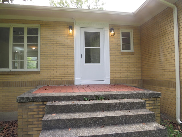 entrance to property featuring brick siding