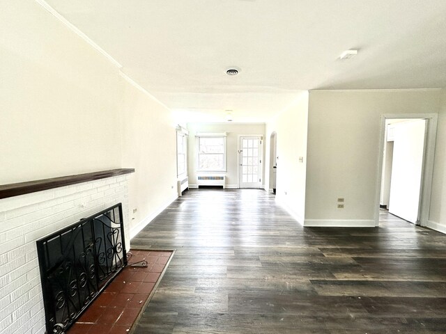 unfurnished living room featuring radiator, baseboards, wood finished floors, and a fireplace