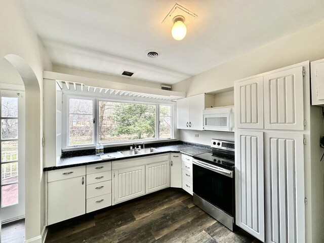 kitchen featuring a sink, dark countertops, dark wood-style flooring, electric stove, and white microwave
