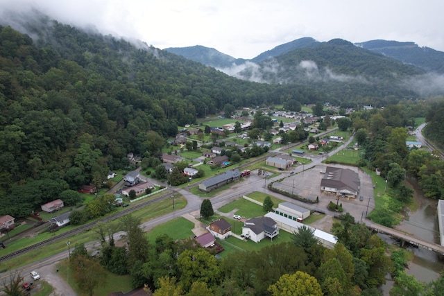 drone / aerial view with a wooded view, a mountain view, and a residential view