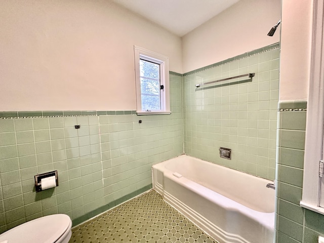bathroom with walk in shower, wainscoting, tile walls, toilet, and a bathtub