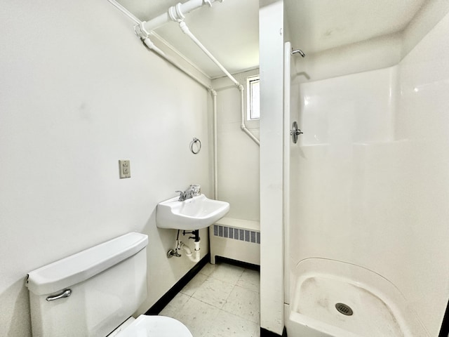 full bathroom featuring radiator heating unit, a shower stall, toilet, and a sink
