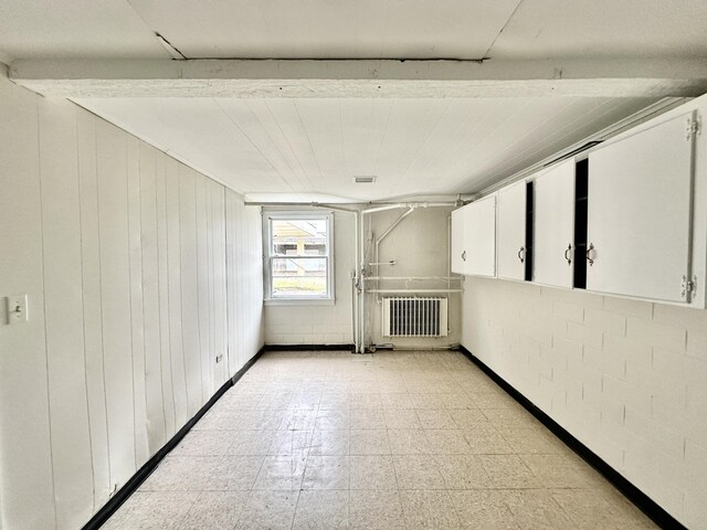 interior space featuring radiator heating unit and light floors