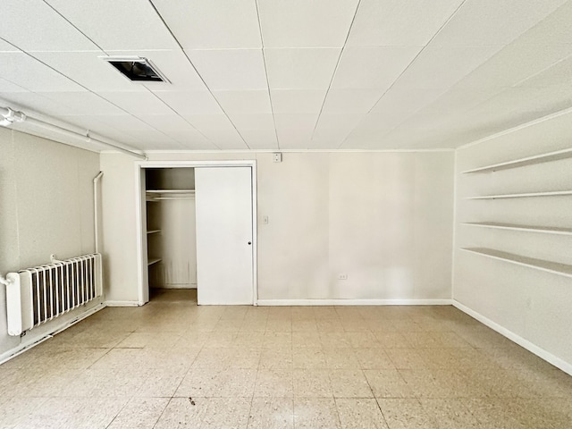 unfurnished bedroom with visible vents, baseboards, a closet, light floors, and radiator heating unit