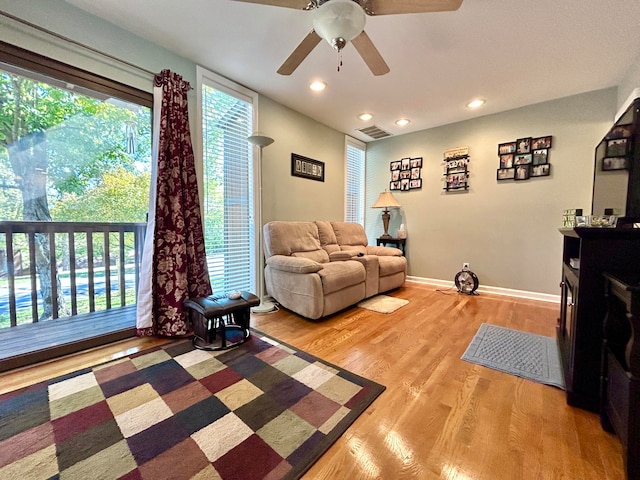 living room with light wood-type flooring and ceiling fan