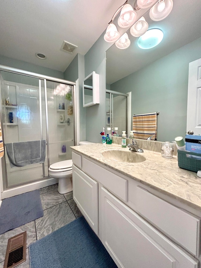 bathroom with vanity, a shower with door, and toilet