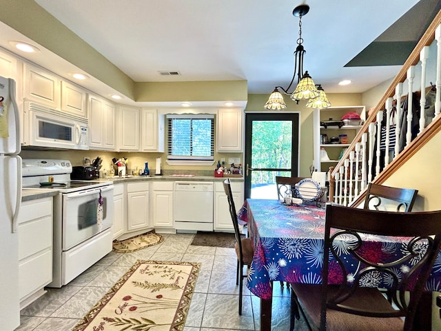 kitchen featuring white cabinets, light tile patterned flooring, hanging light fixtures, and white appliances