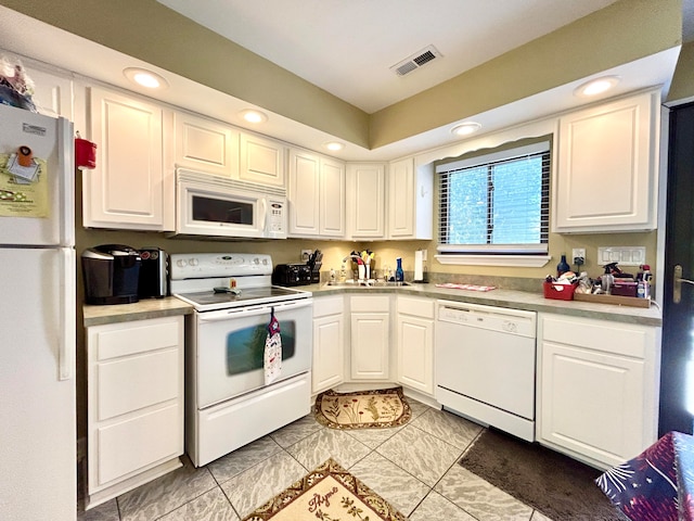 kitchen featuring white appliances, sink, and white cabinetry