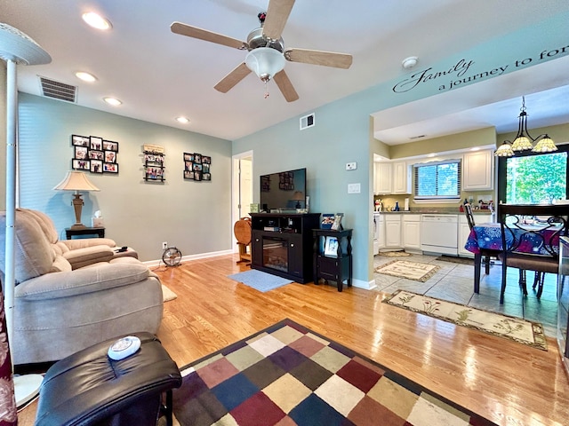 living room with ceiling fan and light hardwood / wood-style floors