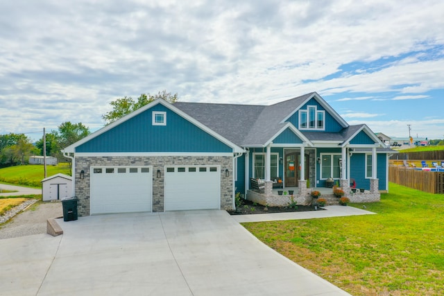 craftsman house with a front yard, a porch, and a garage