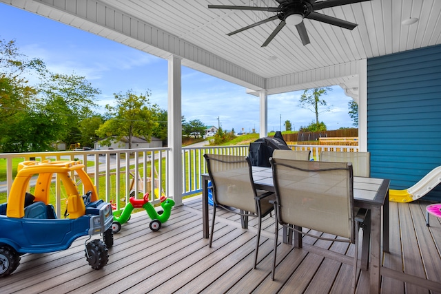 wooden deck with a lawn and ceiling fan