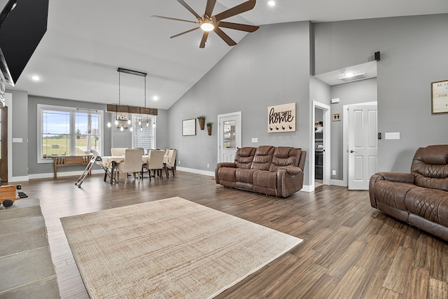 living room with high vaulted ceiling, ceiling fan, and dark wood-type flooring