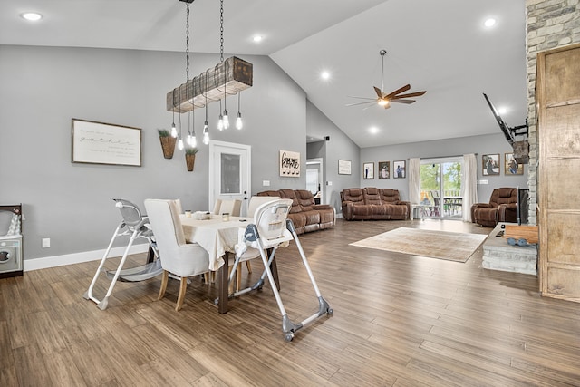 dining space featuring hardwood / wood-style floors, high vaulted ceiling, and ceiling fan