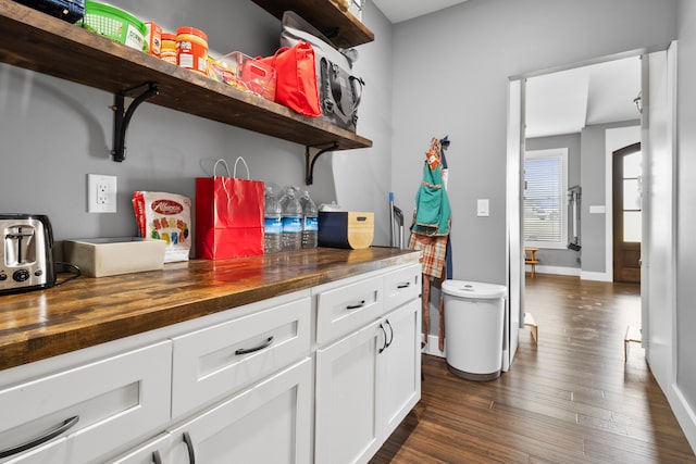 kitchen with white cabinets, butcher block countertops, and dark hardwood / wood-style flooring