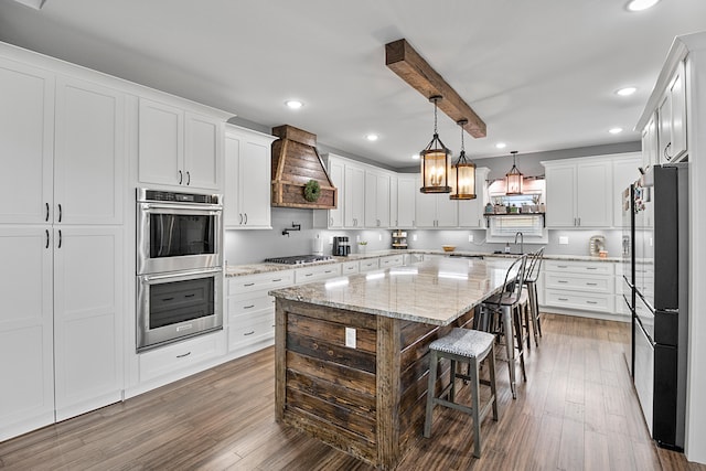 kitchen featuring appliances with stainless steel finishes, premium range hood, and white cabinetry