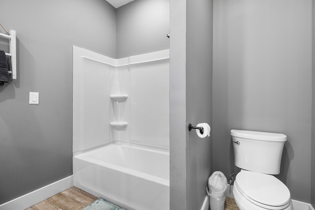 bathroom featuring hardwood / wood-style floors, shower / bathing tub combination, and toilet