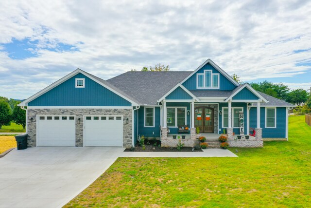 craftsman inspired home featuring covered porch, a garage, and a front lawn