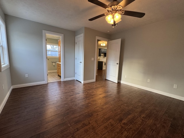 unfurnished bedroom featuring a textured ceiling, dark hardwood / wood-style flooring, ensuite bath, and ceiling fan