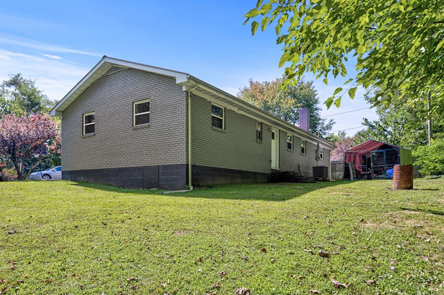 view of side of property with central air condition unit and a lawn