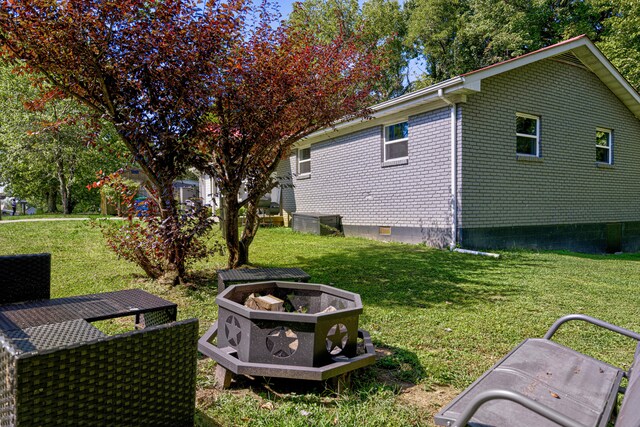 view of yard with a fire pit and central AC unit