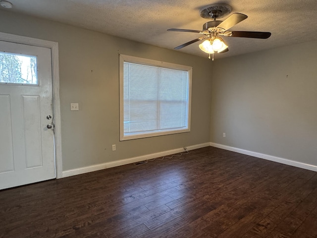 foyer entrance with a textured ceiling, ceiling fan, and dark wood-type flooring