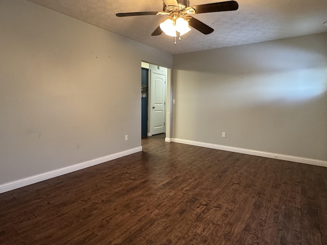 empty room featuring dark hardwood / wood-style floors, ceiling fan, and a textured ceiling