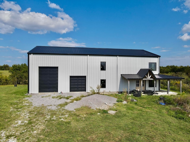 garage with a lawn and covered porch