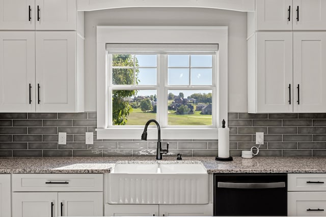 kitchen featuring white cabinetry, light stone counters, tasteful backsplash, dishwasher, and sink