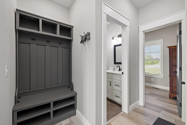 mudroom featuring sink and light hardwood / wood-style floors