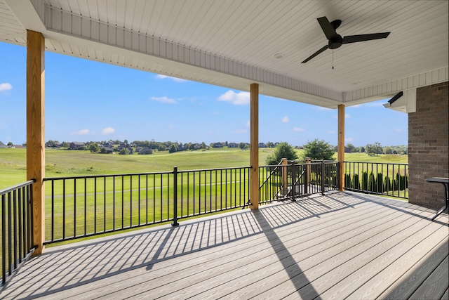 wooden terrace featuring a lawn and ceiling fan