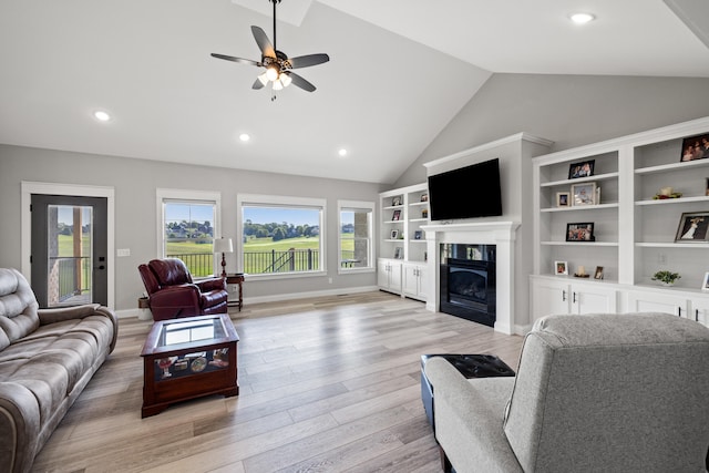 living room with ceiling fan, light wood-type flooring, and high vaulted ceiling