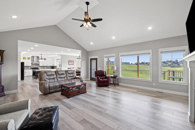 living room with light wood-type flooring, ceiling fan, and high vaulted ceiling