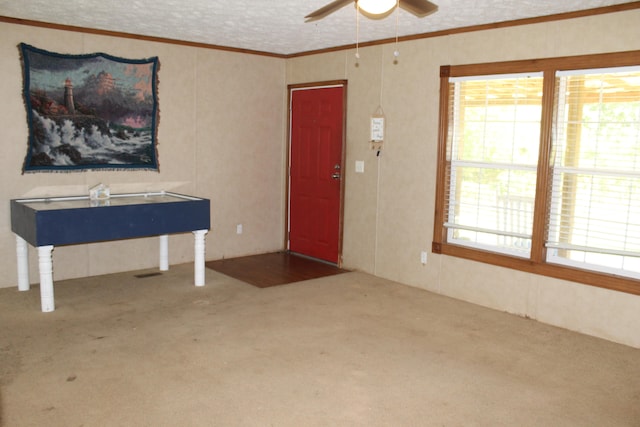 carpeted foyer entrance featuring ceiling fan and a textured ceiling