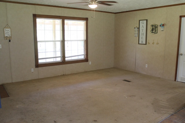 carpeted empty room with ceiling fan and crown molding