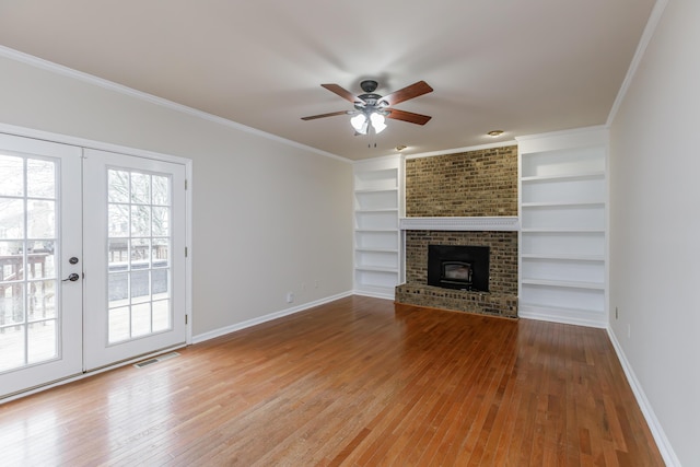 unfurnished living room featuring hardwood / wood-style flooring, ornamental molding, french doors, and built in shelves