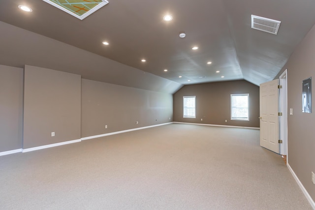 additional living space with vaulted ceiling and light colored carpet