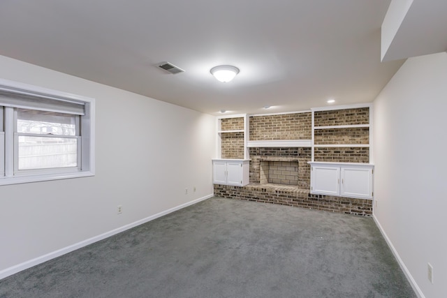 unfurnished living room with a brick fireplace and carpet floors