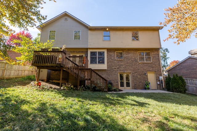 back of property with a wooden deck and a yard