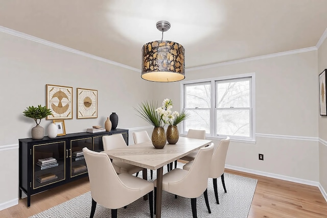 dining room with ornamental molding and light wood-type flooring