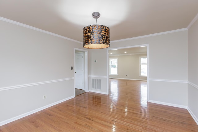 unfurnished dining area with hardwood / wood-style floors and ornamental molding