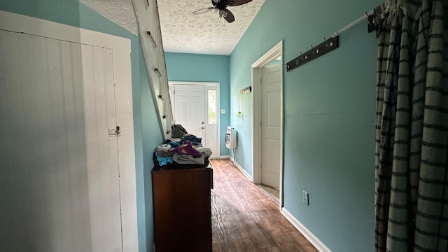 hall featuring wood-type flooring, a textured ceiling, and heating unit