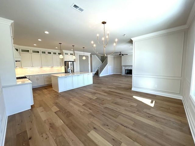 kitchen featuring light wood-style flooring, a fireplace, visible vents, open floor plan, and stainless steel refrigerator with ice dispenser