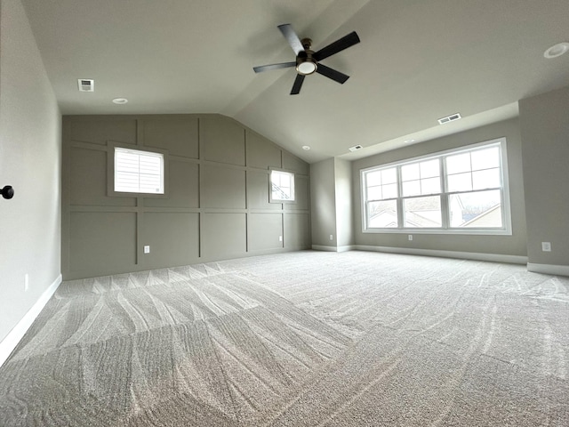 unfurnished room with vaulted ceiling, carpet flooring, and visible vents